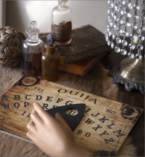 ouija-board-fake-hand-table-high-angle